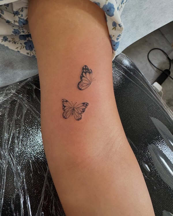 Delicate Pair Of Butterfly Tattoos On Upper Arm