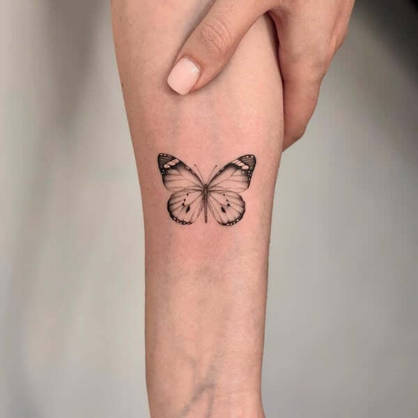 Delicate Black Butterfly Tattoo On Upper Arm