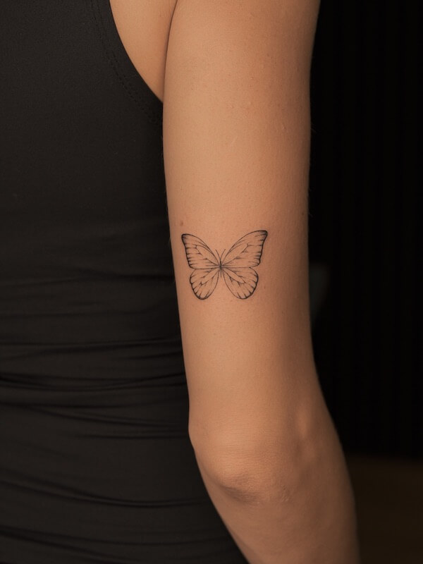 Classic Black Butterfly Tattoo On The Back Of The Upper Arm